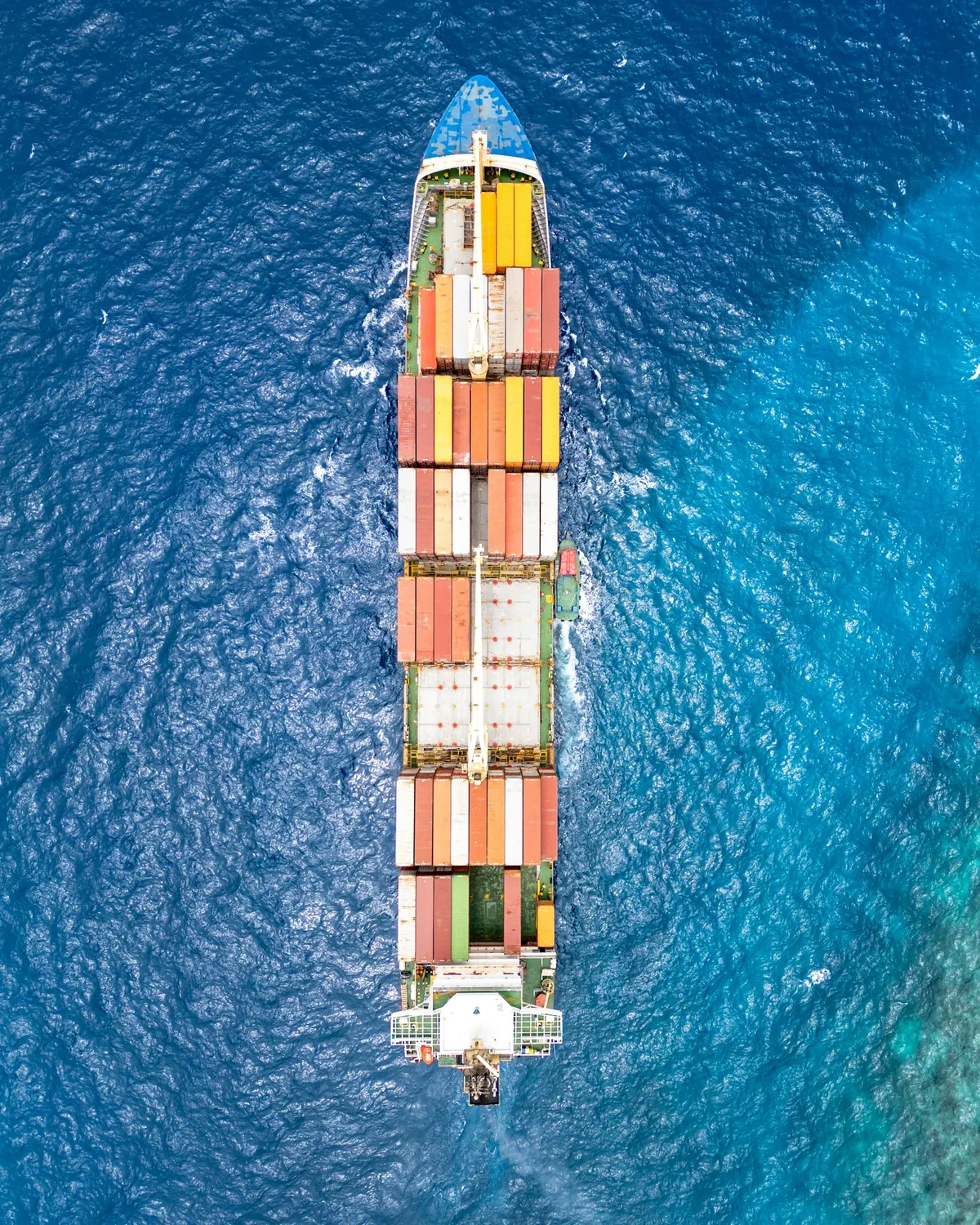 Aerial view of a container ship carrying freight across deep blue water